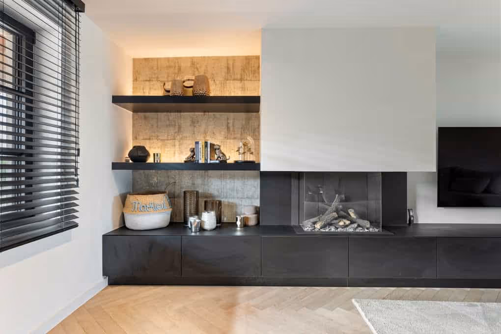 Professionele interieurfotografie van een strakke, donkere keuken met indirecte verlichting en houten werkblad.