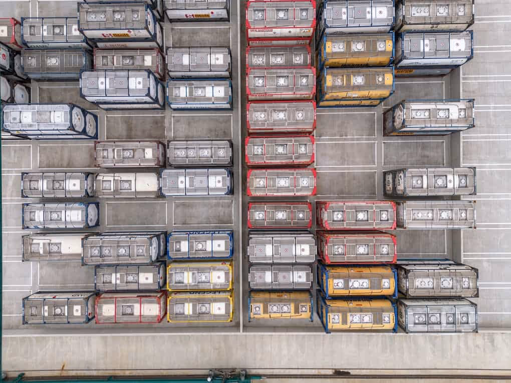 Industriële vastgoedfotografie van gestapelde containers en opgeslagen goederen.