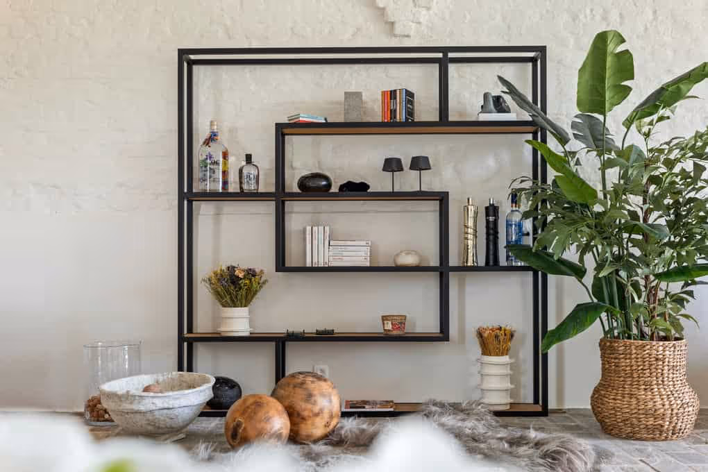 Interieurfotografie van een moderne woonkamer met open, zwarte boekenkast en decoratieve items.