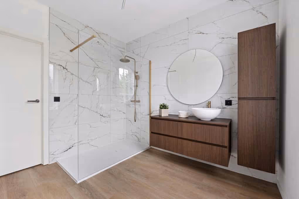 Vastgoedfoto van een moderne badkamer met inloopdouche, spiegel en houten wastafelmeubel.