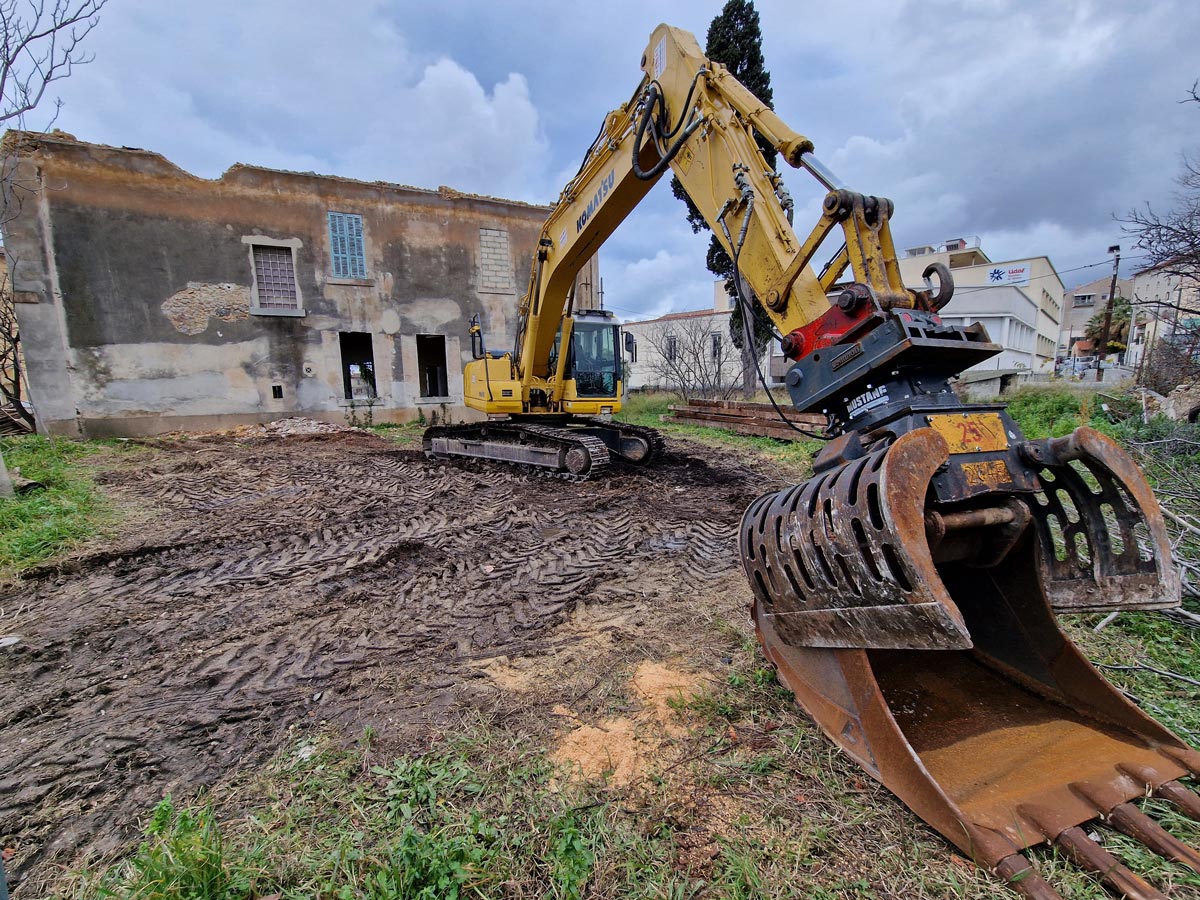Engin de démolition devant une vieille bâtisse à Marseille