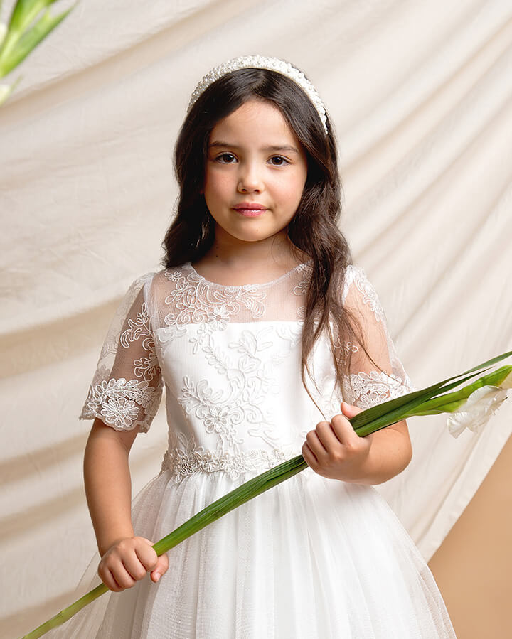 little girl wearing dress holding flower