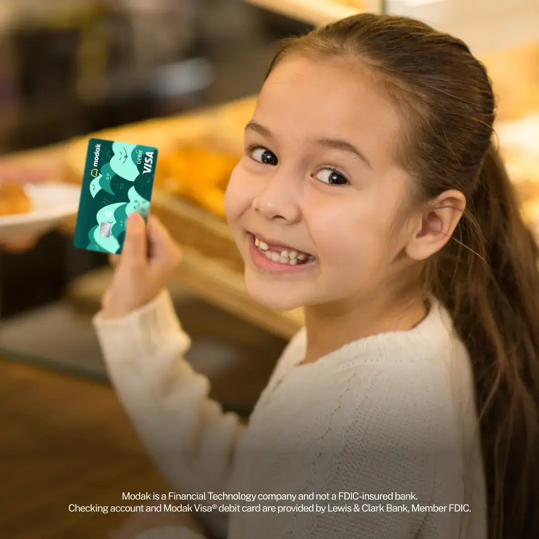 Girl holds Modak visa debit card for kids