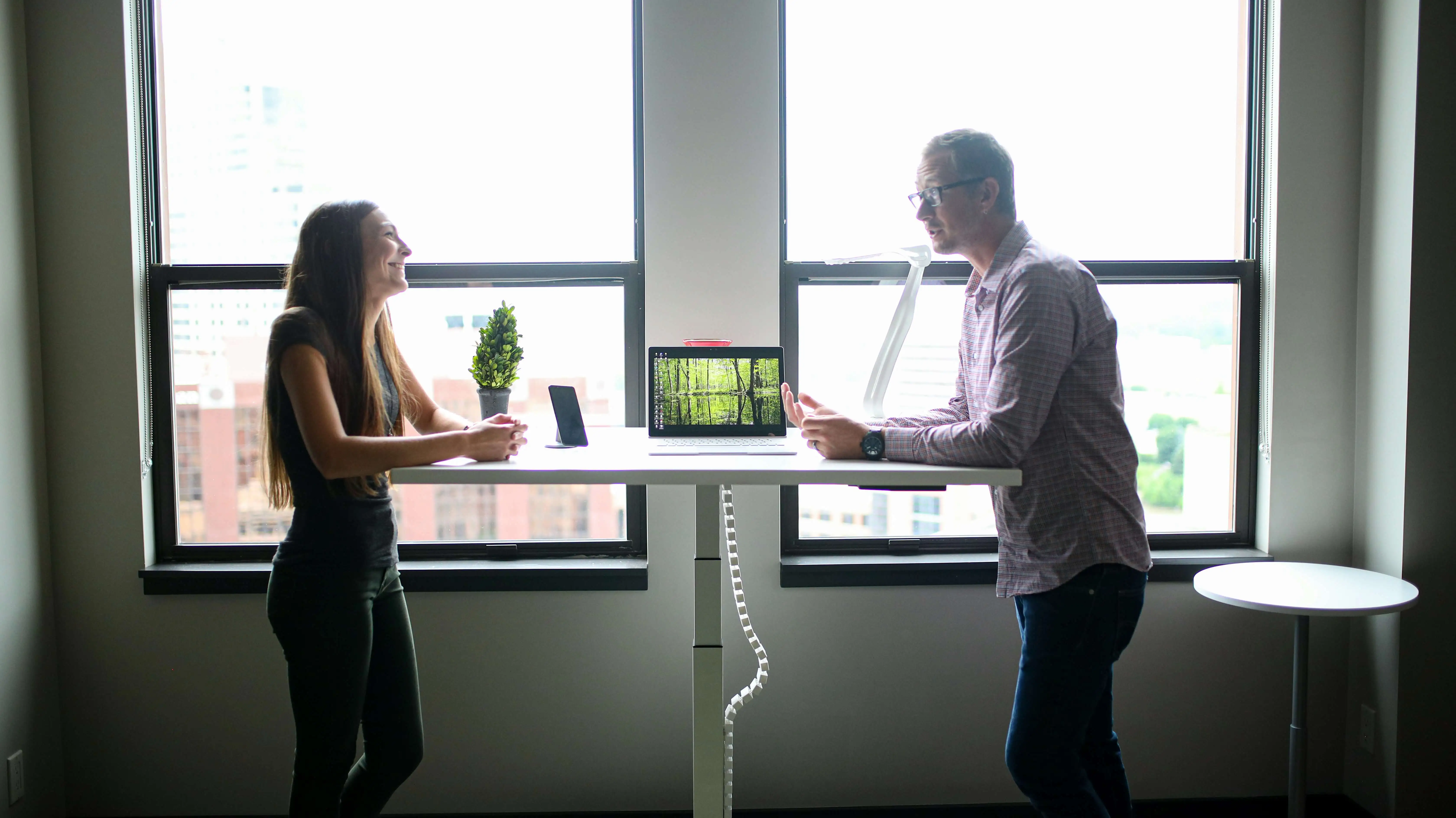 Two persons talking in a standing desk