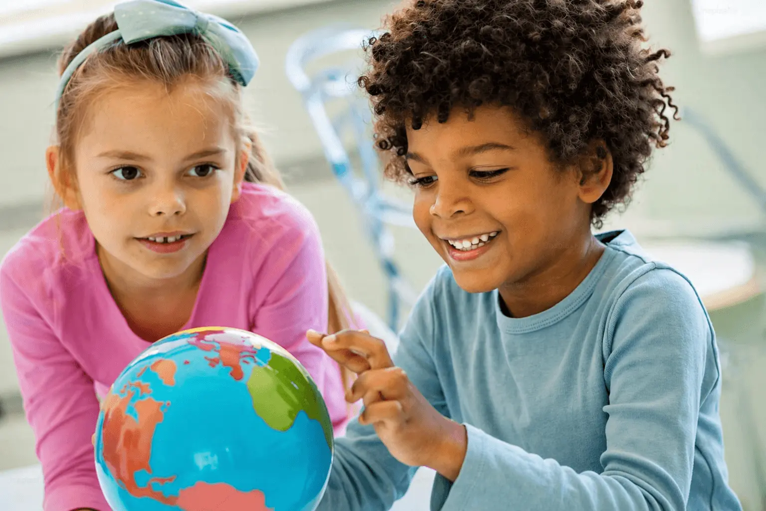 Two kids playing with a globe