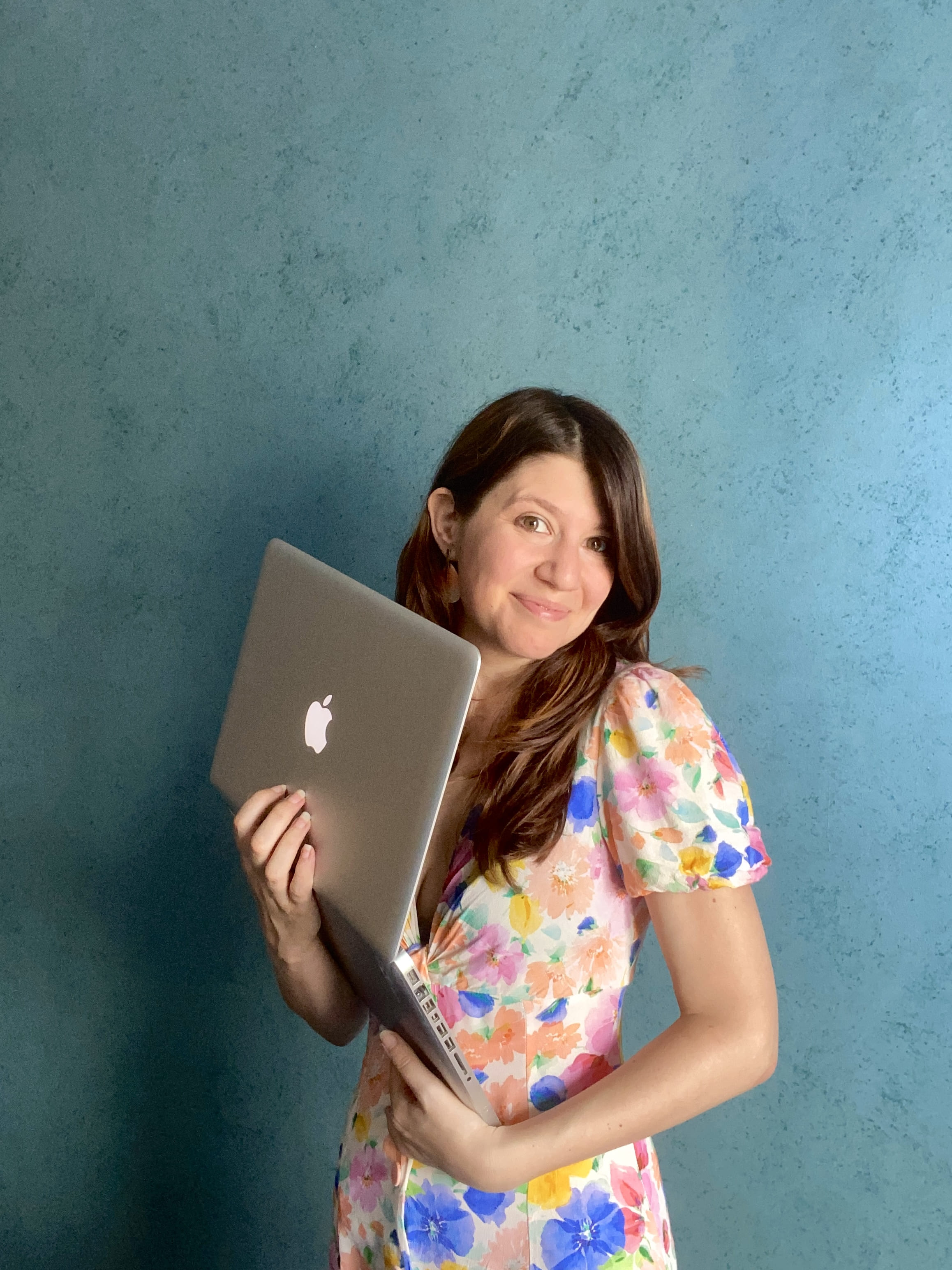 Coach business et révélatrice de potentiels, accompagnant les entrepreneurs atypiques et conscients, regardant l’objectif avec un mac dans les mains