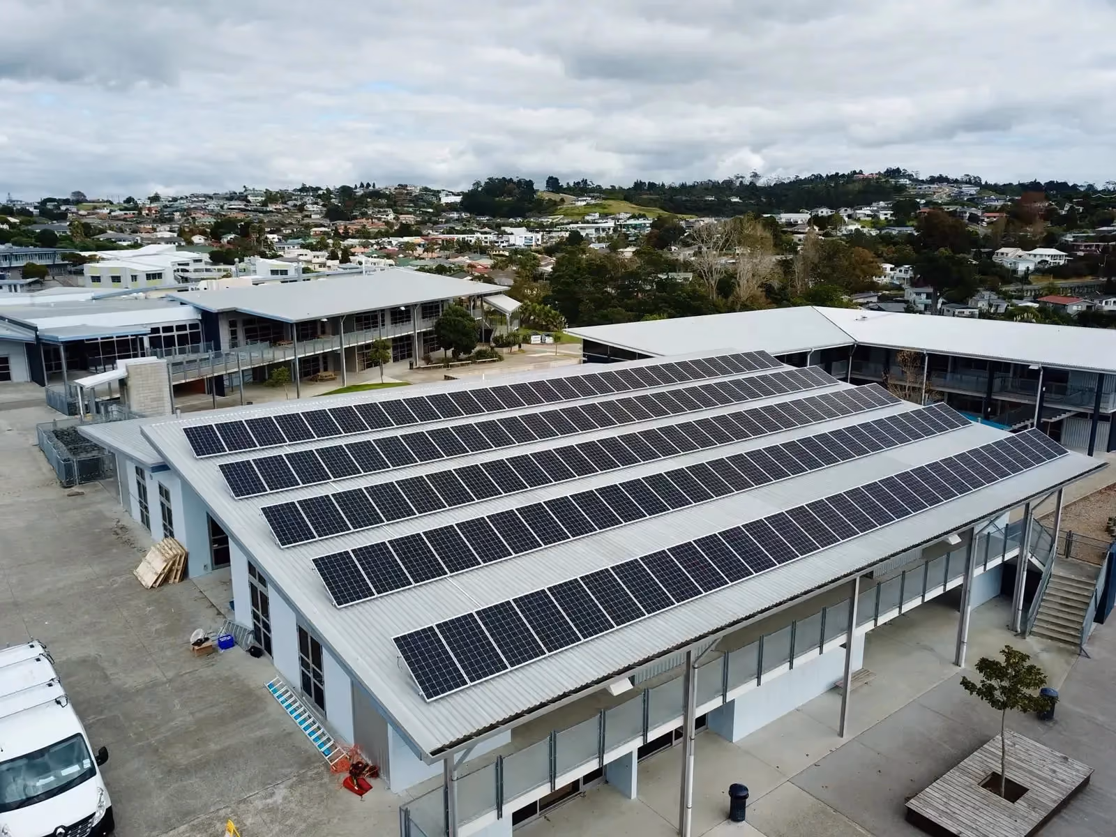 An aerial view of Whangaparaoa College in Auckland, with solar panels on the roof.