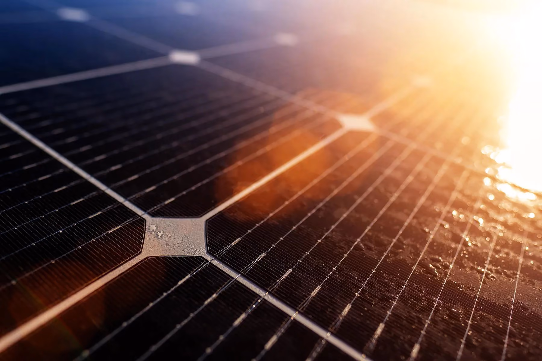 A close up of a solar panel with the sun shining on it.