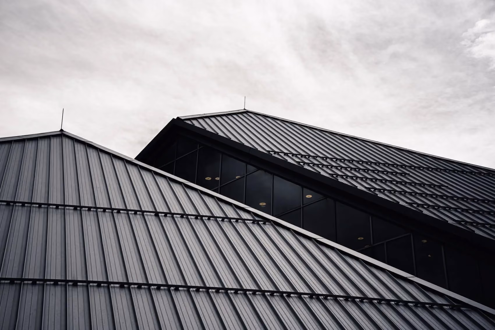A black and white photo of a building with metal roofs.