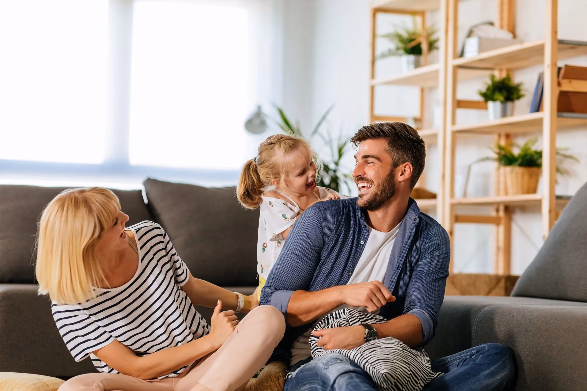 Happy family sitting on the floor in the living room.