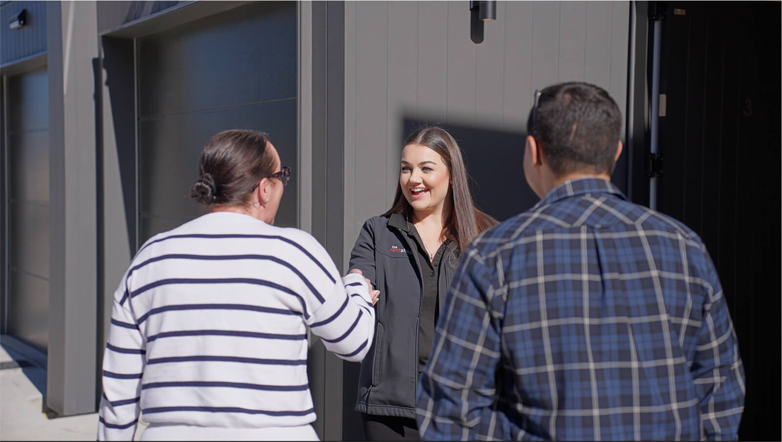 A Rent Shop team member shaking hands with clients.