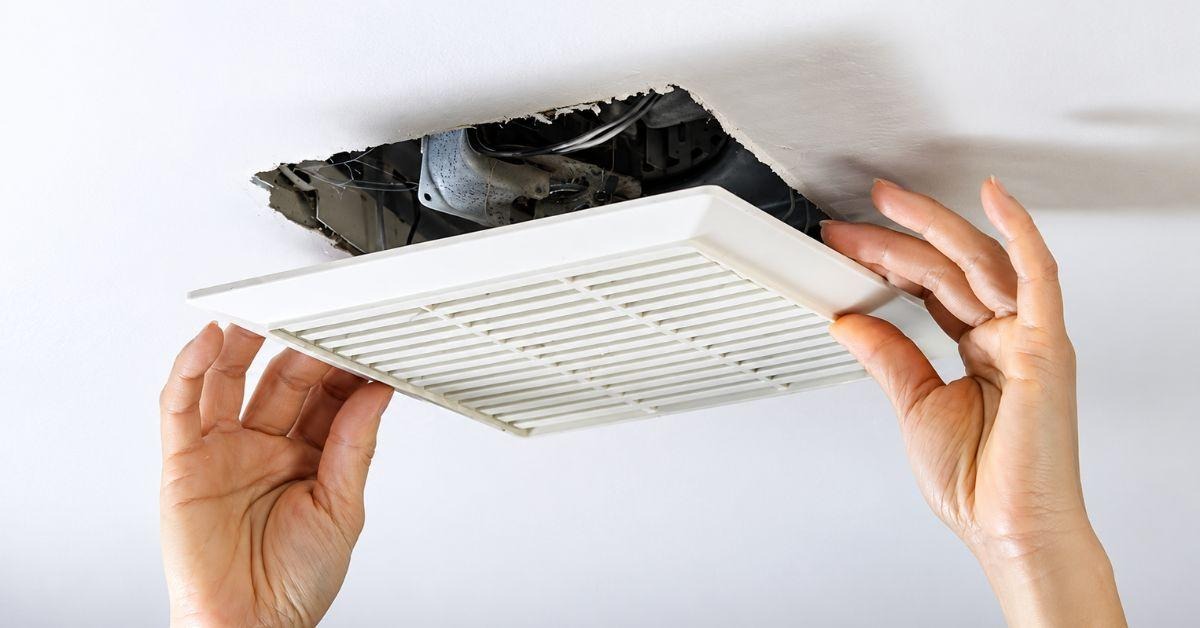 Ceiling extractor fan cover being removed to check ventilation during a Healthy Homes inspection