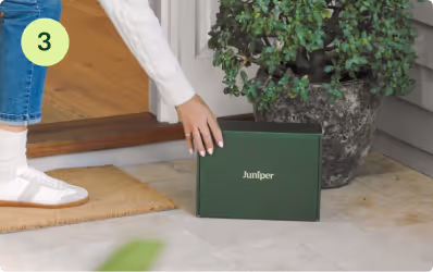 woman picking up juniper box outside door
