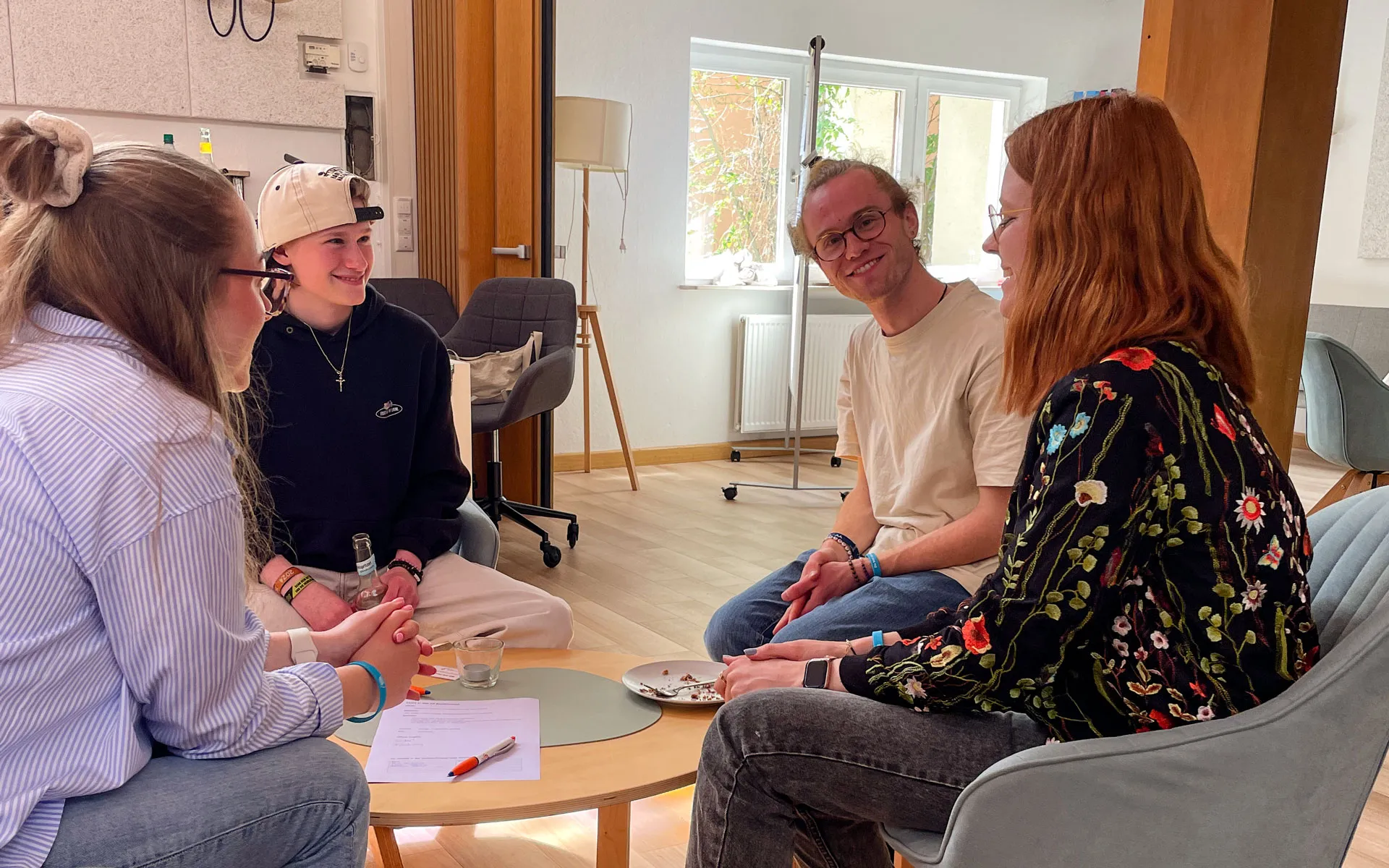 In der Lukaskirche sitzen vier Menschen um einen Tisch und sind im Gespräch.