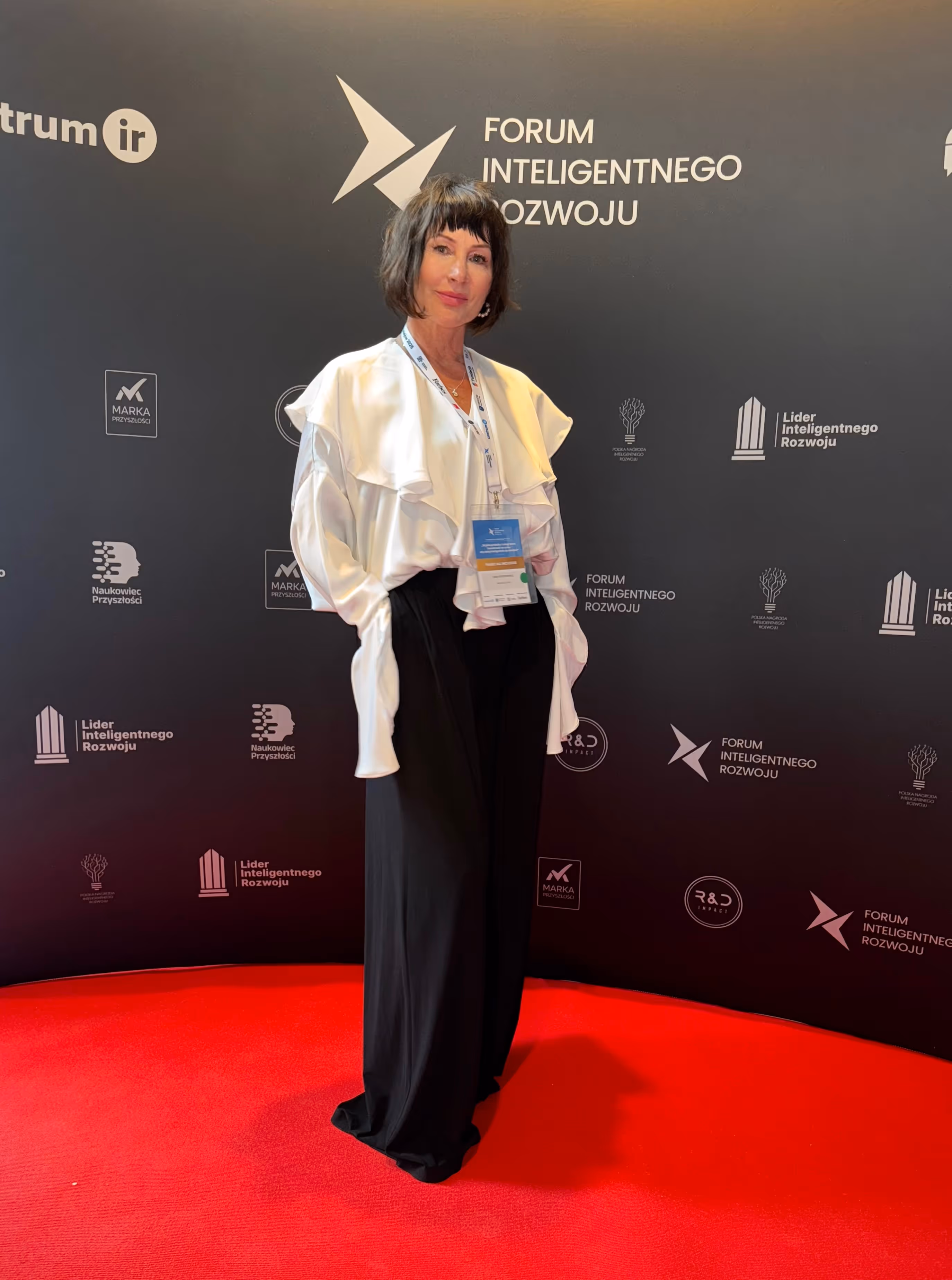 Ewa Abramowicz stoi na tle ścianki  "Forum Inteligentnego Rozwoju"