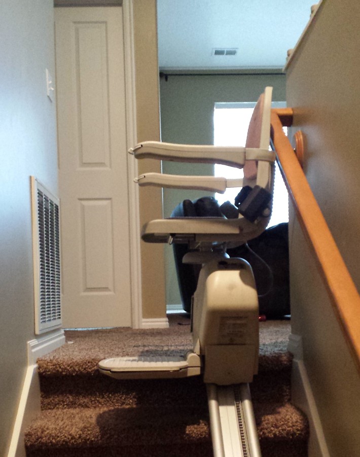 Reconditioned Acorn stair lift installed on indoor staircase for affordable senior mobility solutions.