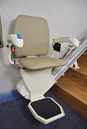 Stair lift with beige swivel seat, safety belt, and footrest installed on a residential staircase for enhanced mobility.