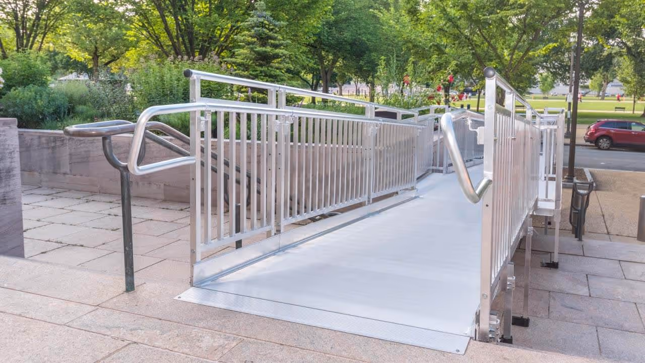 Outdoor stair lift installed along a residential staircase with metal railing, designed for safe and accessible mobility for seniors and individuals with disabilities.
