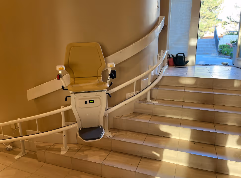Portable wheelchair ramp being used for easy access over stairs, providing mobility assistance for individuals with disabilities.