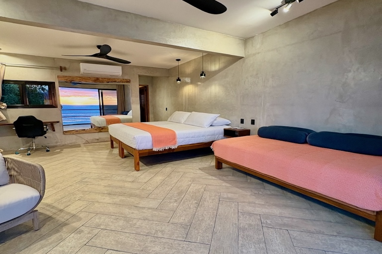 Spacious interior of the Wave View Room at Miramar SurfCamp with seating area and ocean view