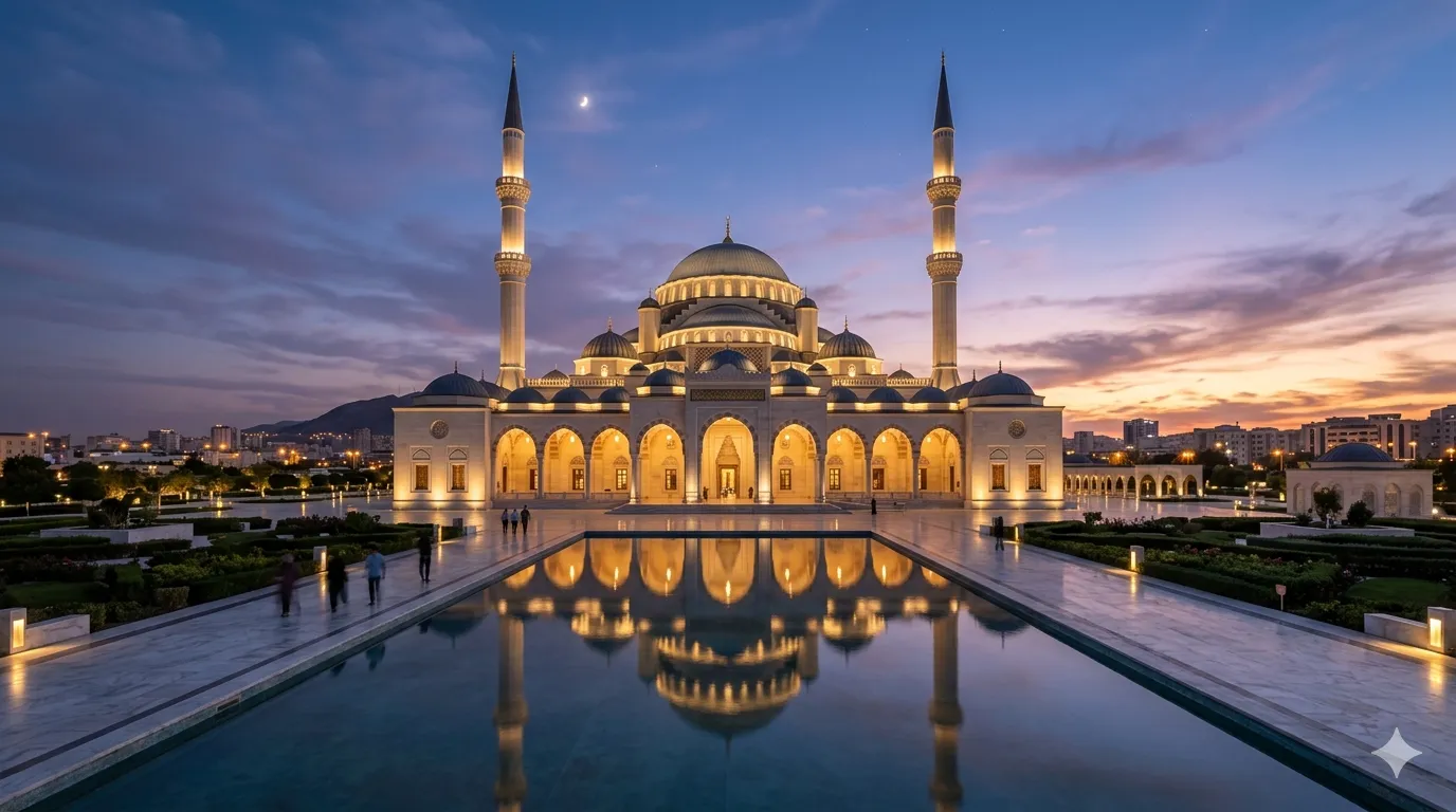 A grand mosque with illuminated arches and tall minarets is mirrored in a reflective pool at sunset. The sky is painted in purple and orange hues.