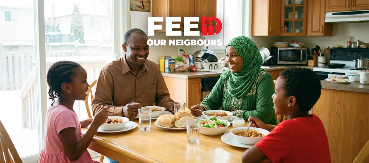 A family of four smiles while sharing a meal at a kitchen table. The words "Feed Our Neighbours" appear above, conveying warmth and community support.