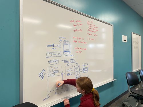 A student sketching on a whiteboard