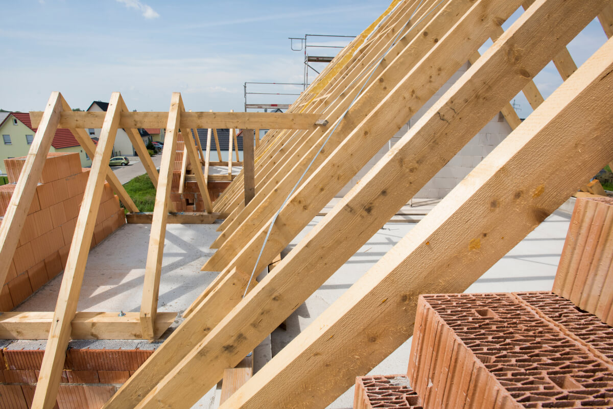 Rohbau eines neuen Hausdachs mit sichtbaren Holzbalken und Dachboden