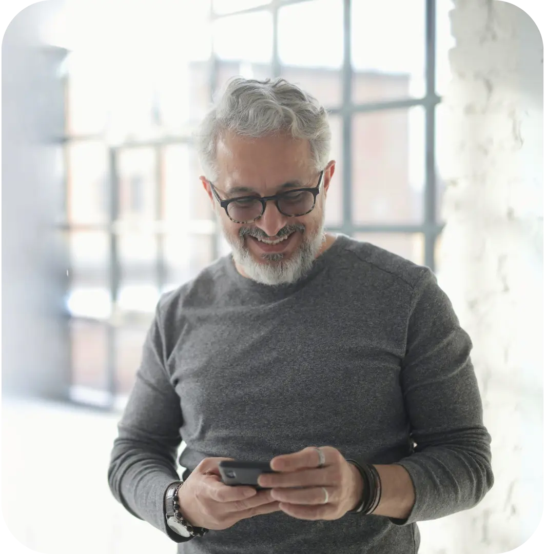 A man smiling while using the Noctua Care App on his smartphone