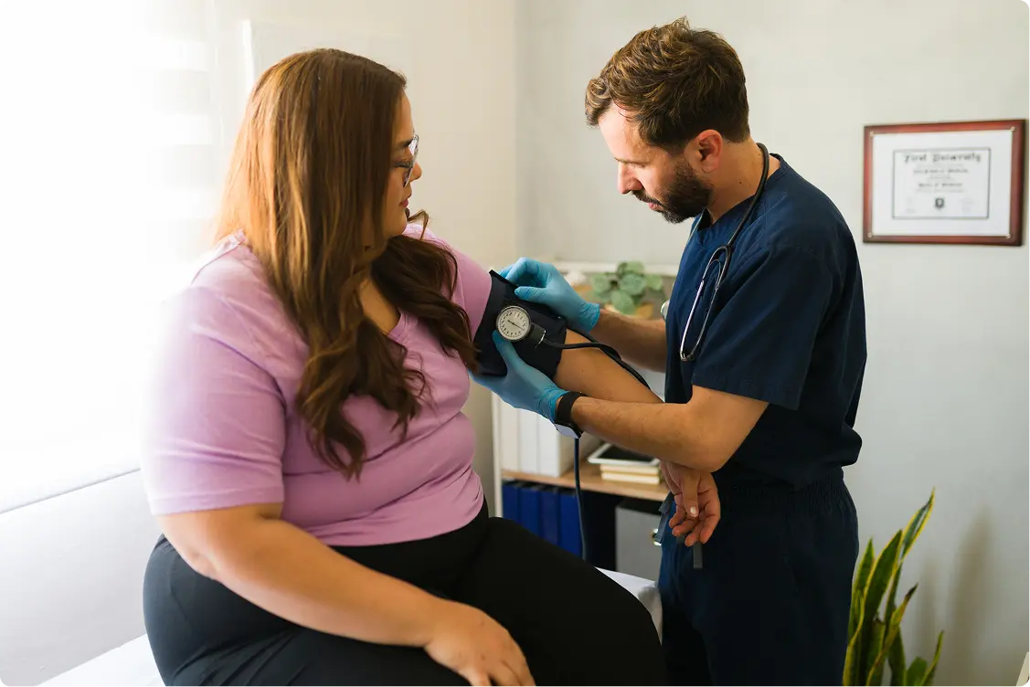 Doctor showing information on a tablet to a patient in a medical office setting.