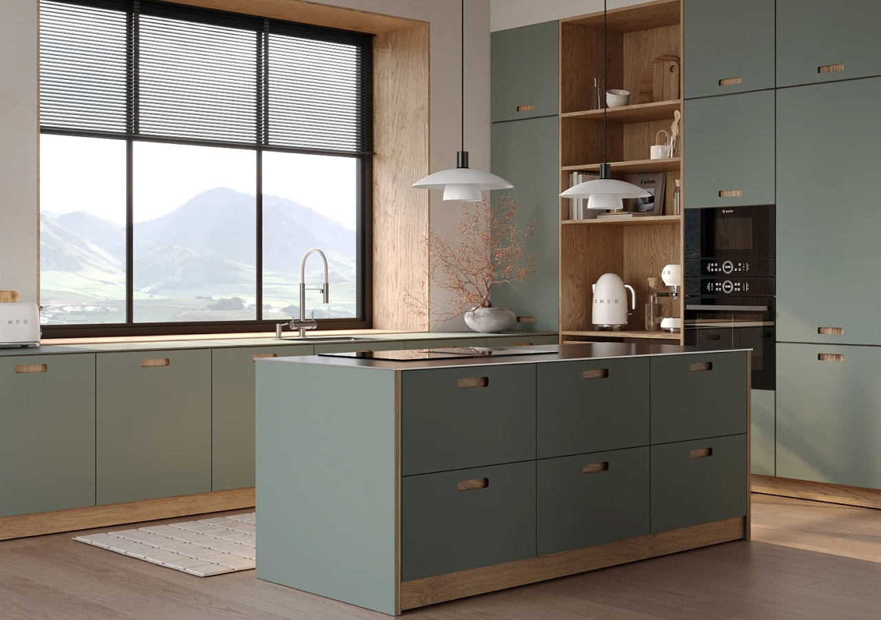 Scandinavian kitchen in matte sage green with oak trim and shelving, functional island, and large window overlooking mountain views.