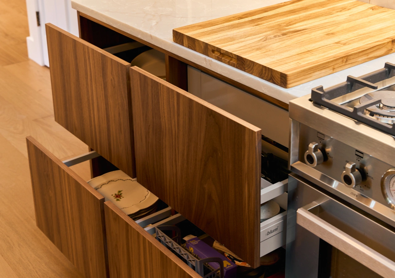 Walnut drawers pulled out with a cutting board and organizers
