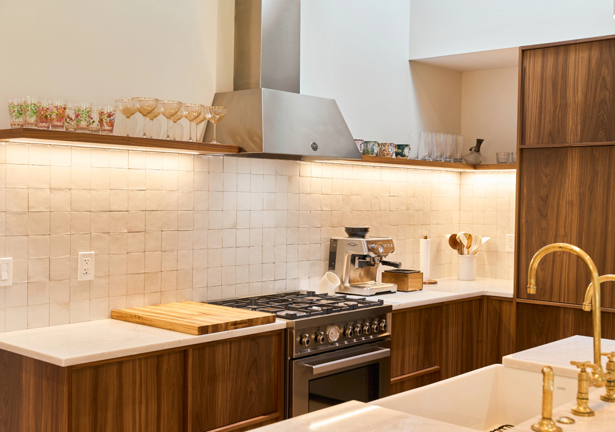 Walnut kitchen without upper cabinets, white tile backsplash and a range