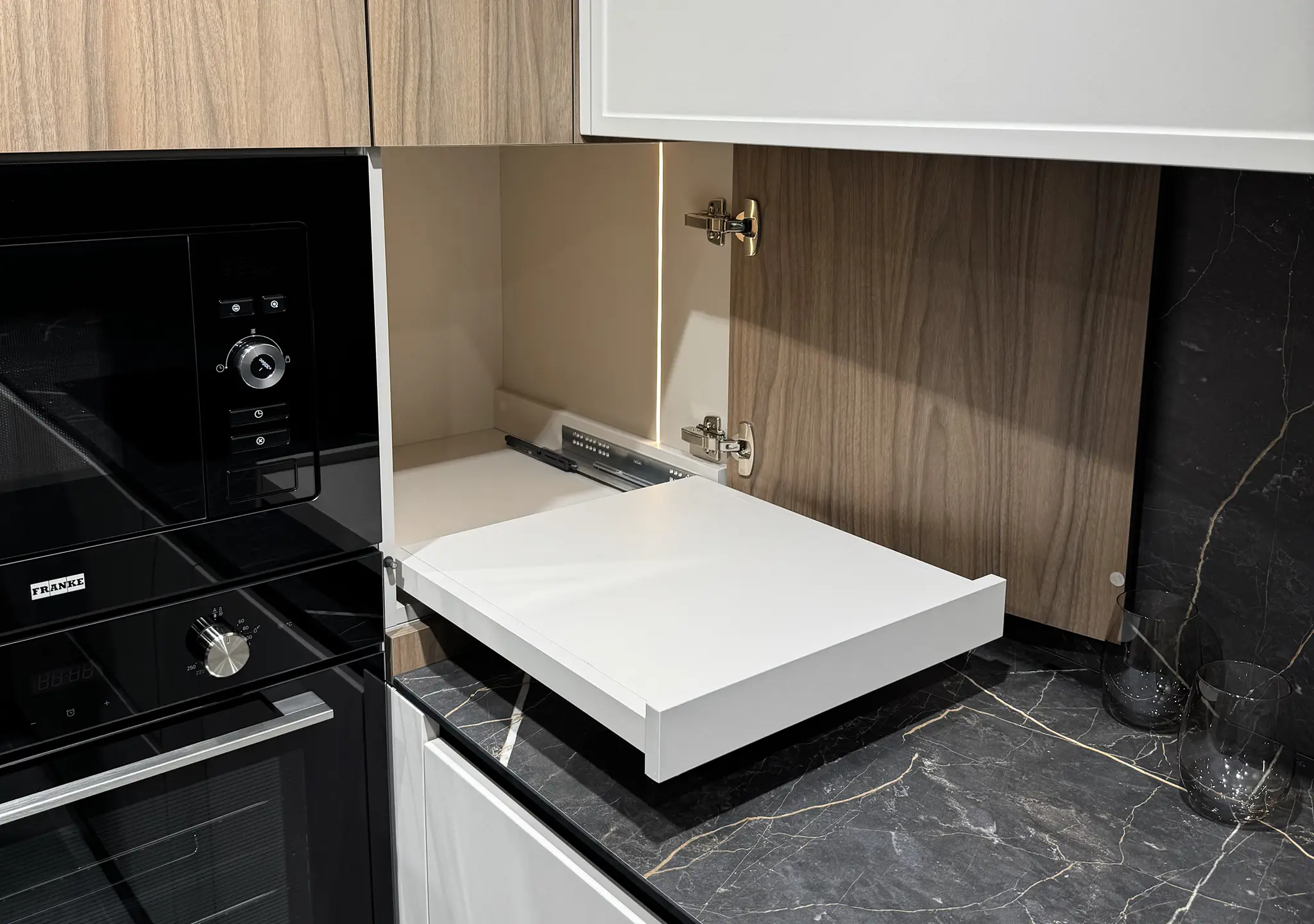 Black kitchen drawer open with a white pull-out tray