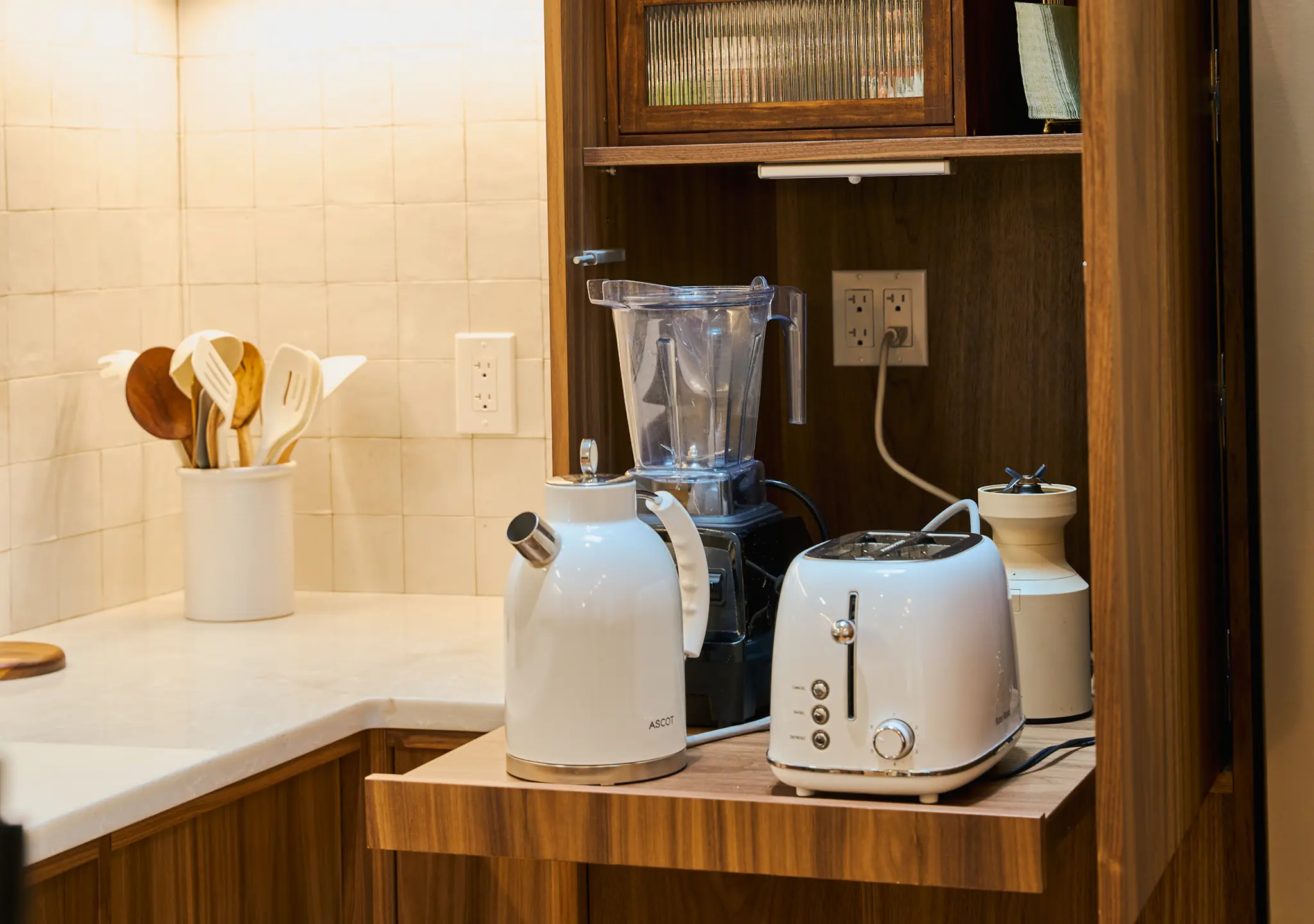 Oak appliance garage open with a blender, kettle and toaster inside