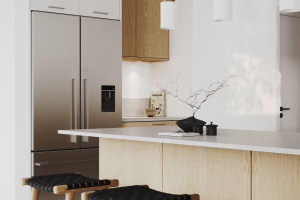Oak kitchen with a stone-topped island, wooden stools and a stainless steel fridge