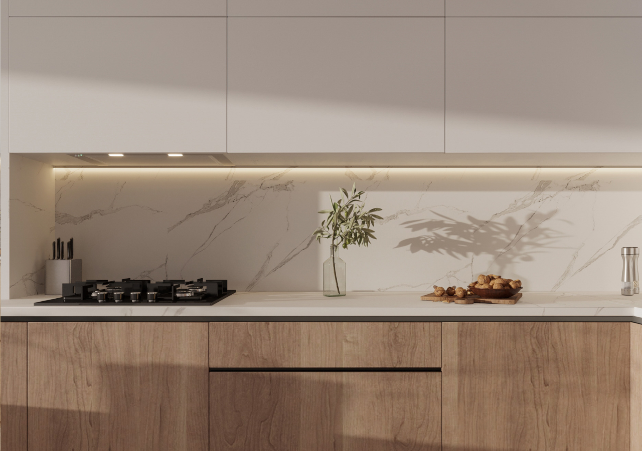 Oak cabinets with a lit marble backsplash and a cutting board