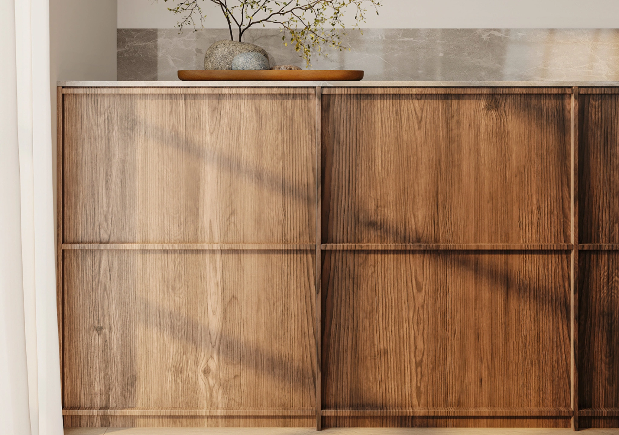 Walnut kitchen cabinets with slab doors and a small vase on top