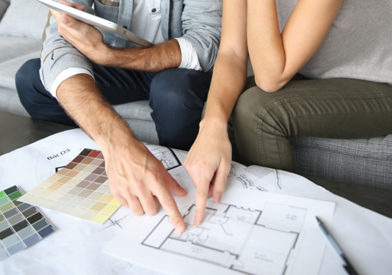 Couple reviewing a kitchen floor plan at a table