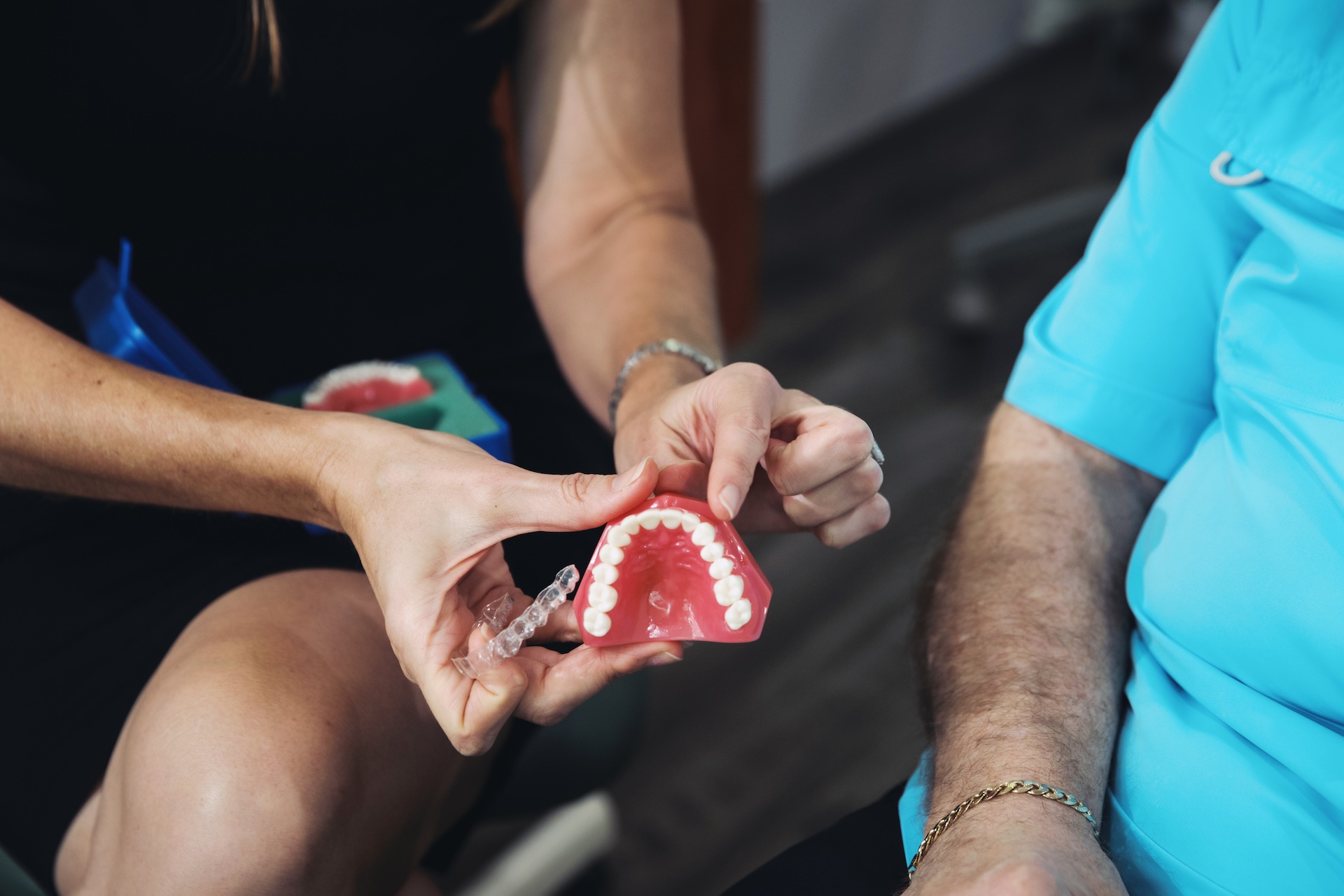 doctor at Aesthetic Dentistry of Stuart showing a patient a teeth model with Invisalign