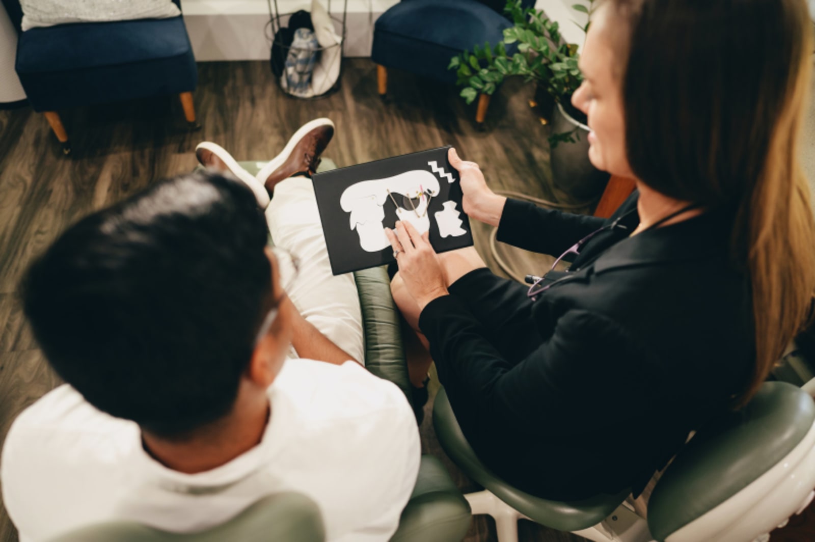 Dental professional showing X-rays to parents during an orthodontic consultation appointment.