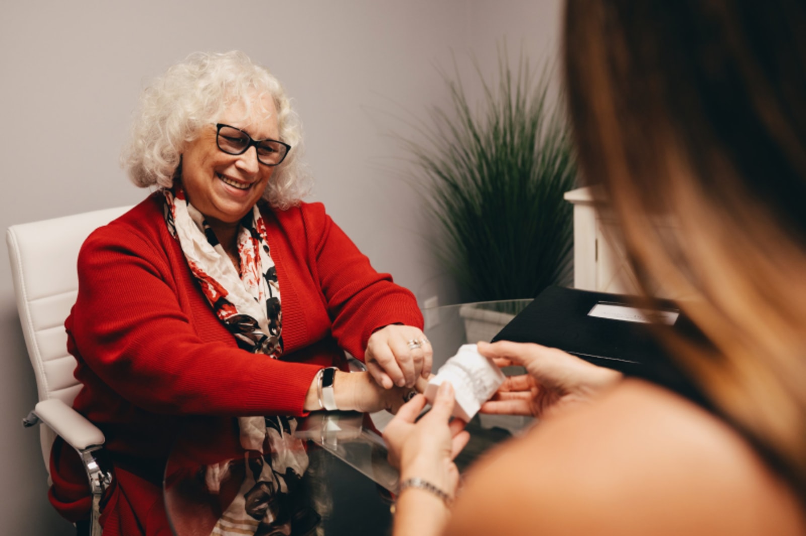 Patient in red clothing with dentist during follow-up consultation