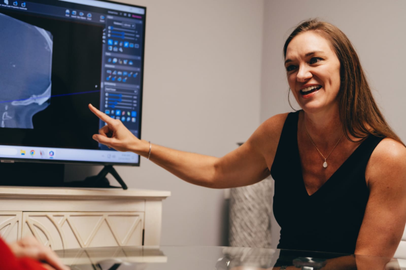 Dental professional displaying an intraoral scanner while discussing treatment with patient