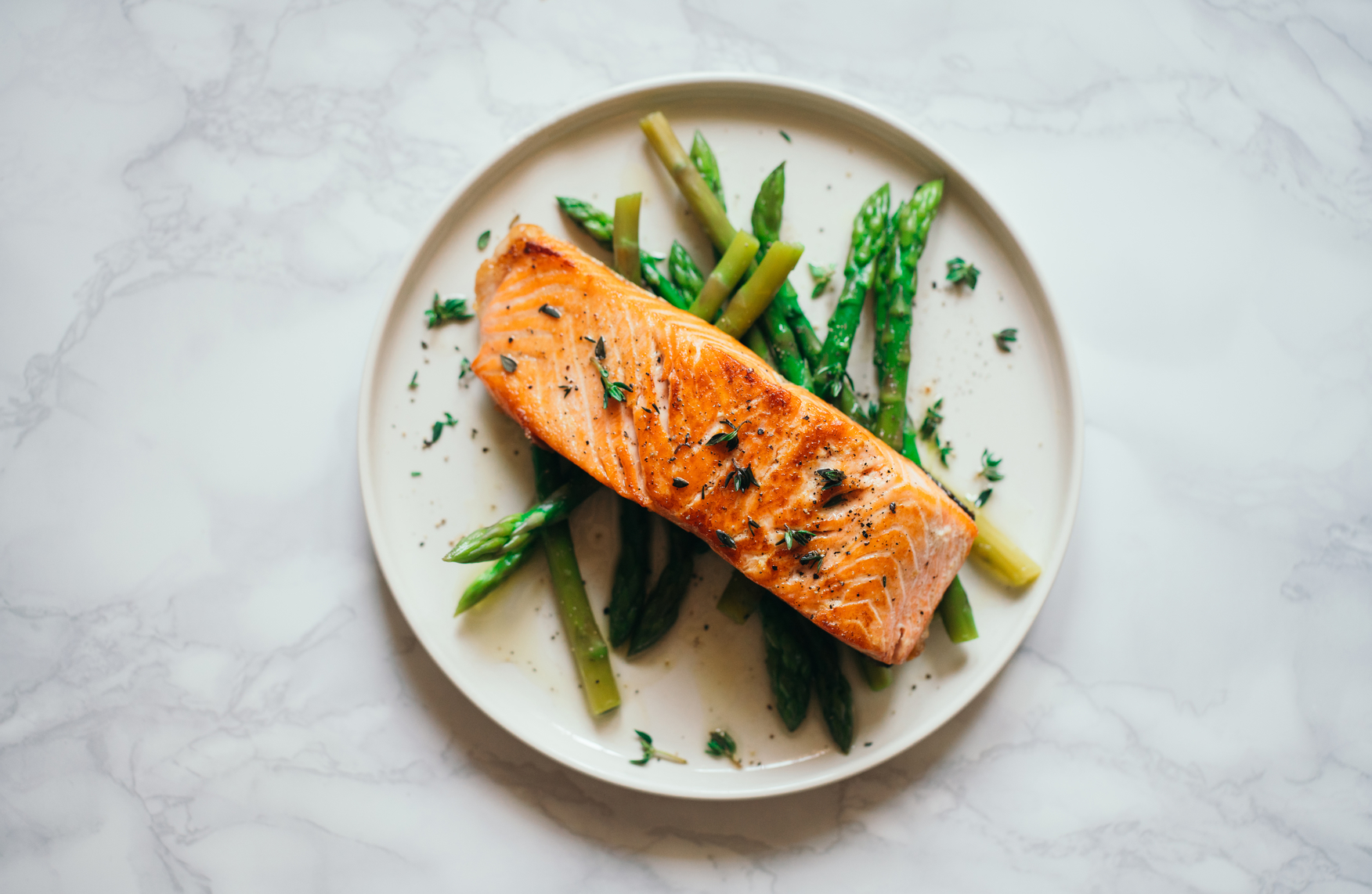 Roasted salmon with asparagus on a white plate