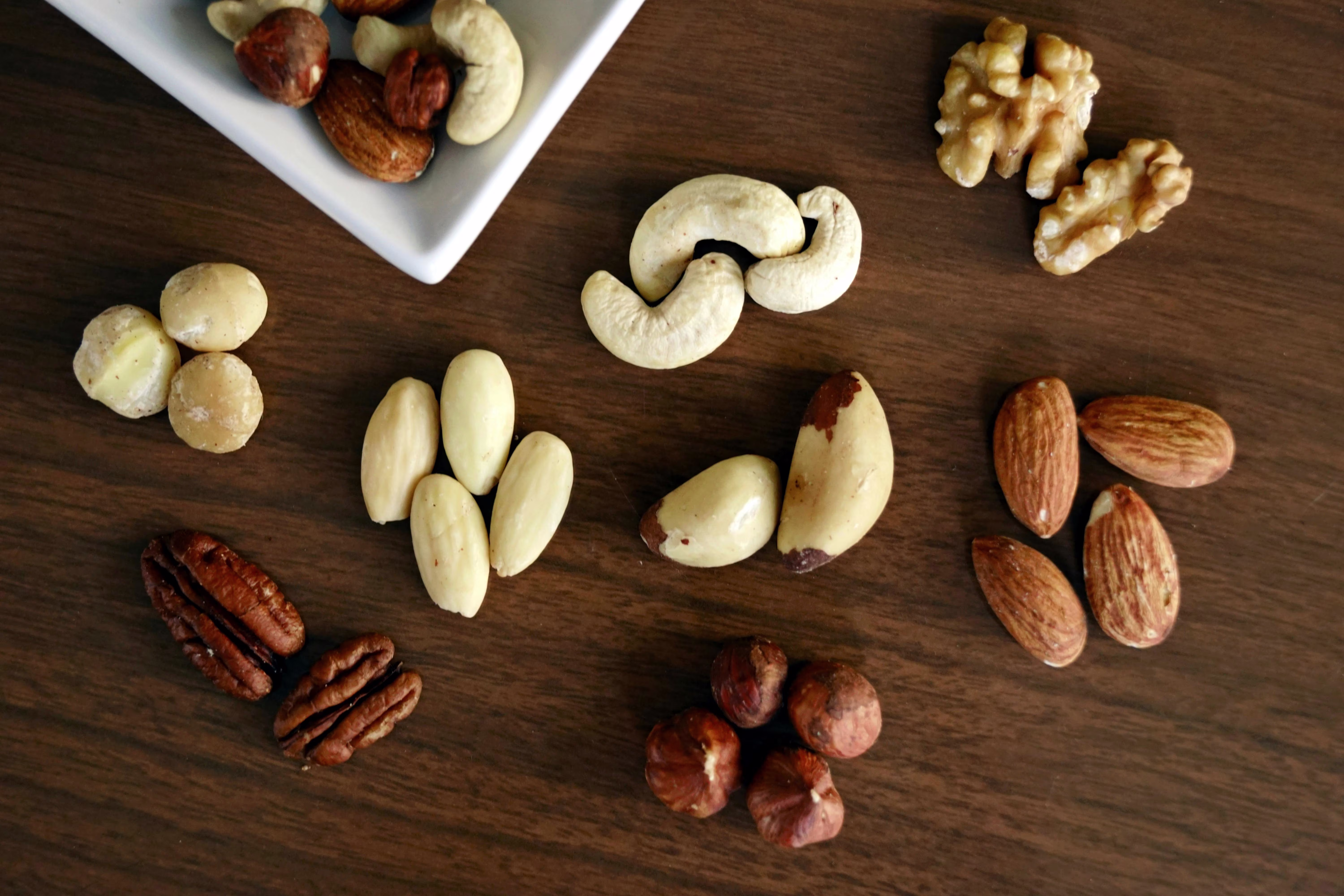Variety of Brown Nuts on Brown Wooden Panel High-angle Photo 