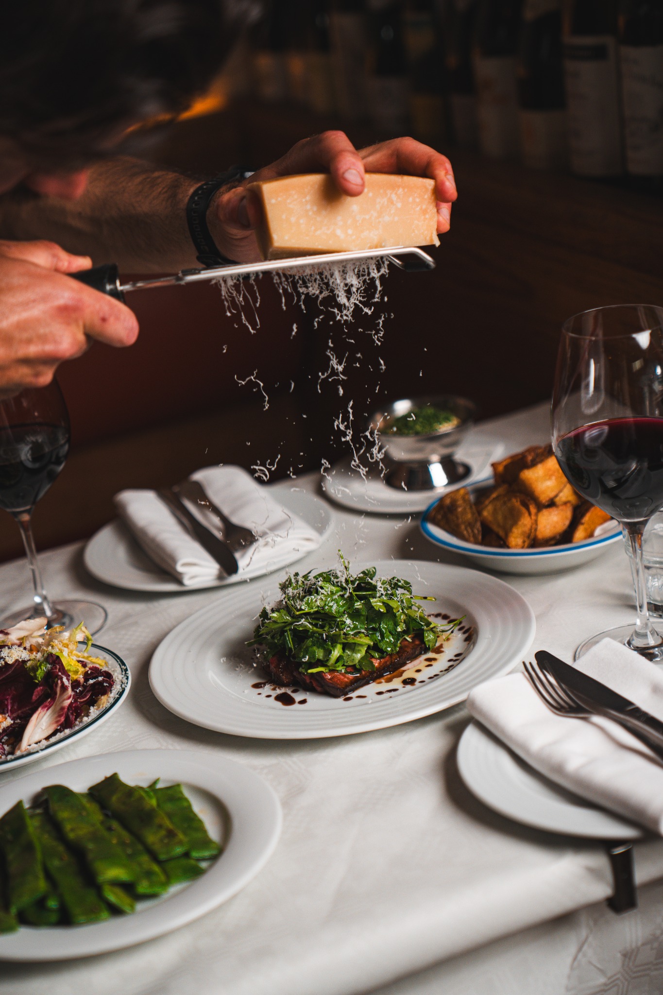 Parmesan grated over a shared dining dish at Bar Bellini