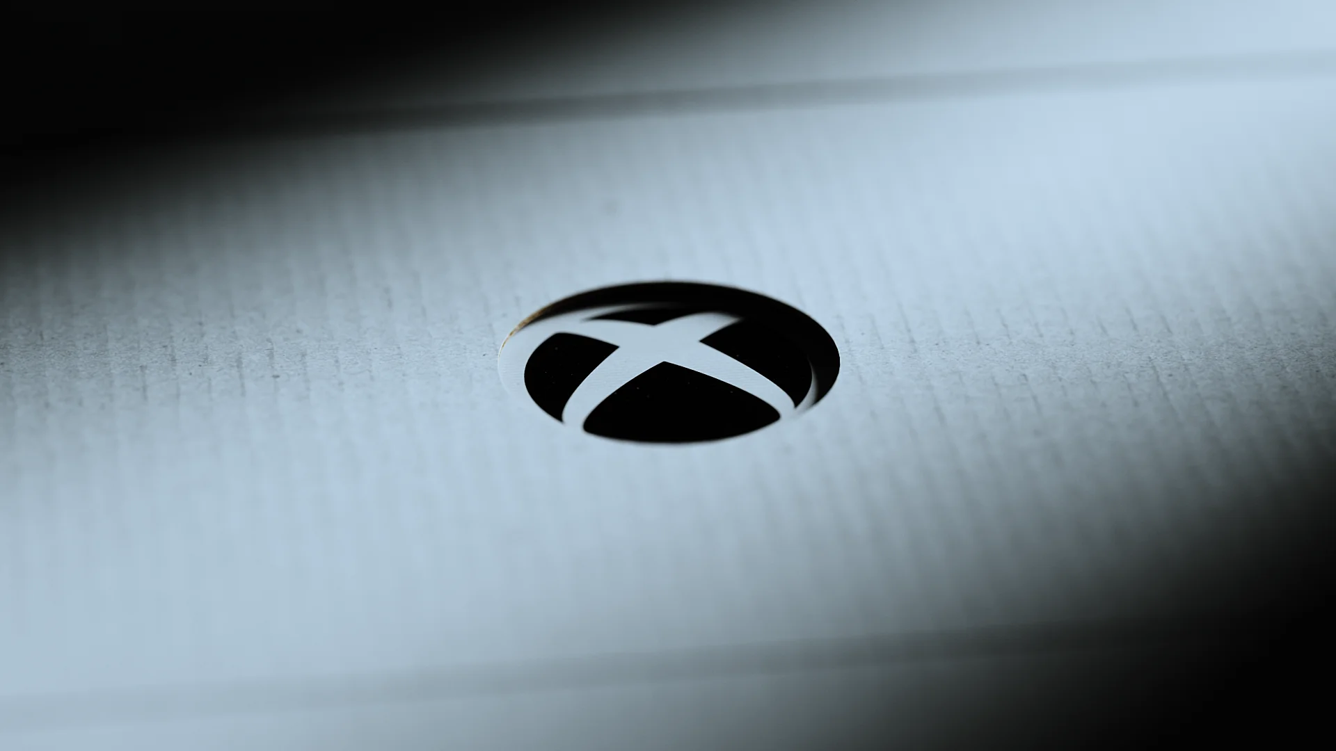 Macro close-up of the XBOX logo embossed on white console packaging