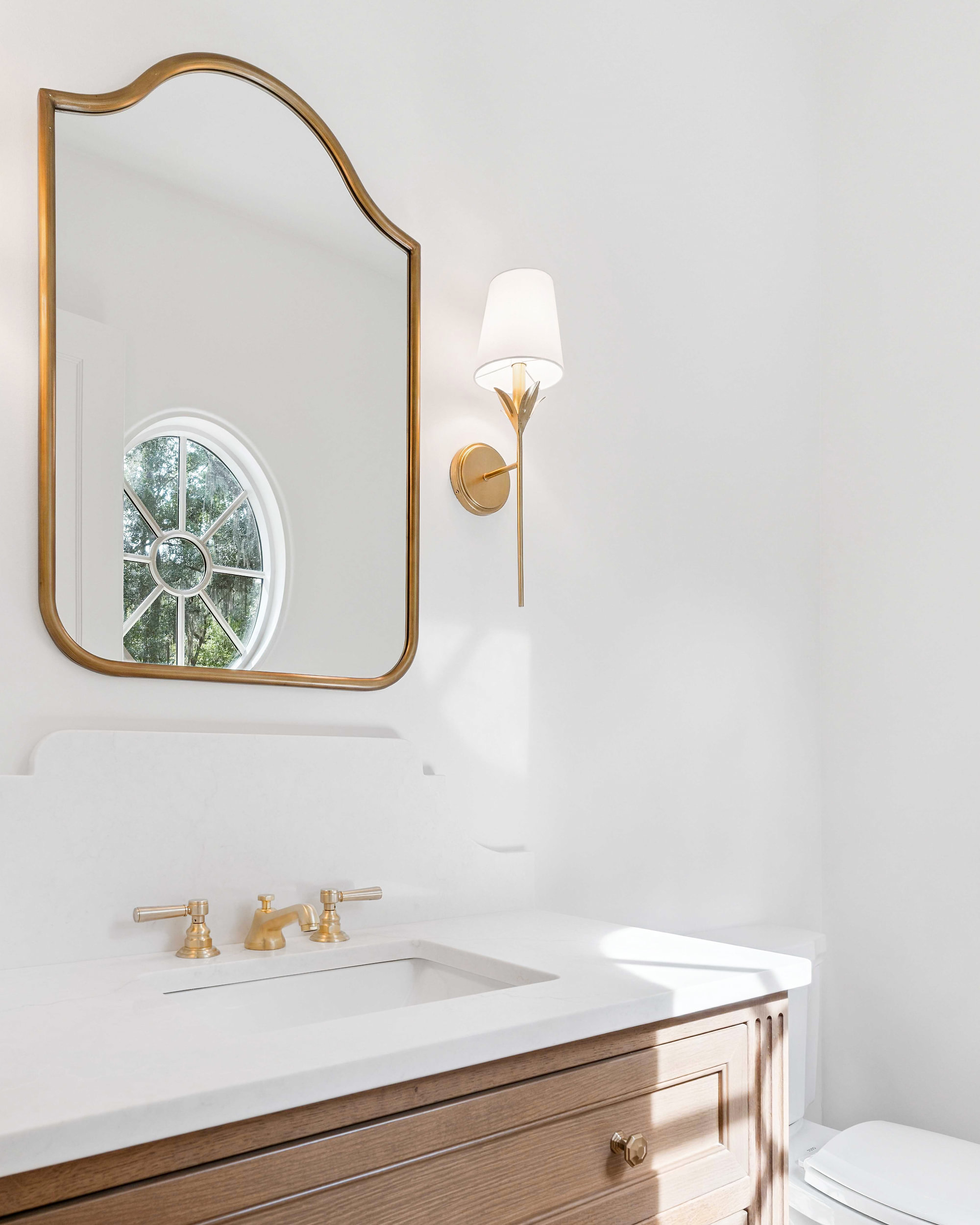 Moss Grove, Flanagan Development, St. Simons Island: powder room with brass mirror and sconce