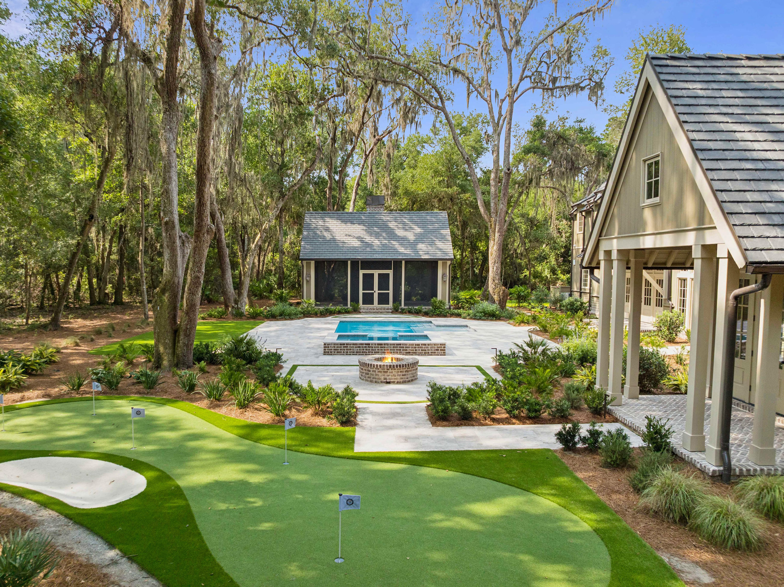 Moss Grove, Flanagan Development, St. Simons Island: backyard with putting green, fire pit and pool house
