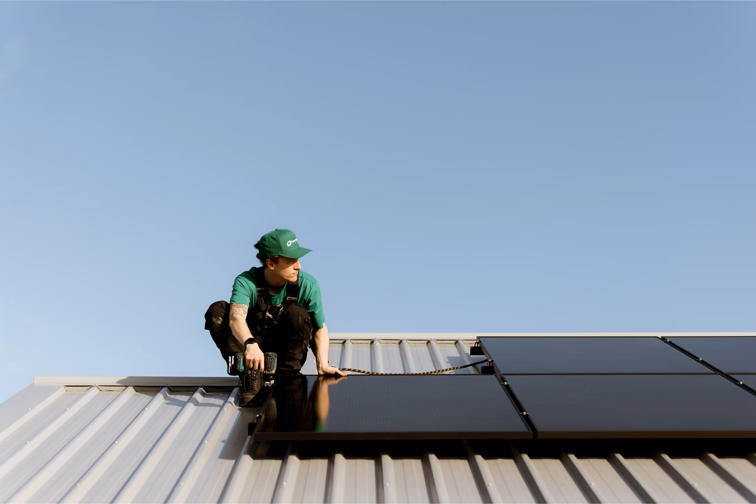 A Harrisons Solar team member installing solar panels on a clients roof.